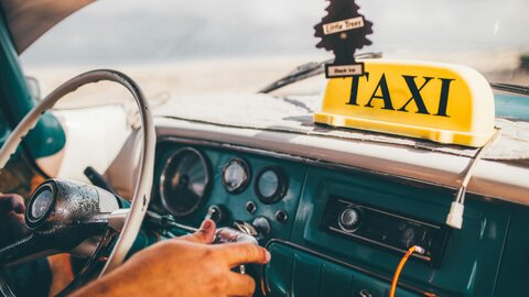 Conductor usando una app de transporte en su móvil dentro del auto